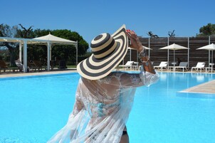 Una piscina al aire libre de temporada, sillones reclinables de piscina