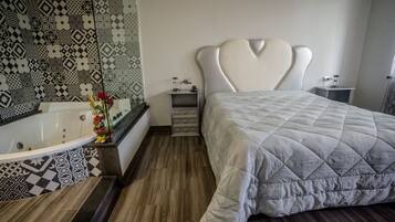 Ein modernes Schlafzimmer mit einem großen Bett, einem herzförmigen Kopfteil, einer Badewanne und Wandverkleidung mit Muster.