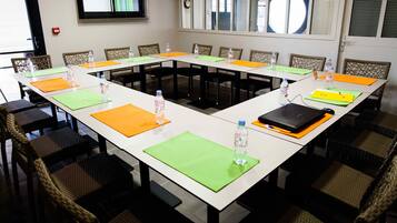 A conference room with a long table, chairs, and water bottles.