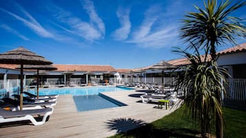 Una piscina al aire libre, sillones reclinables de piscina