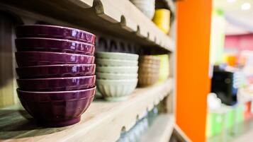 A shelf with stacked bowls of various colors.