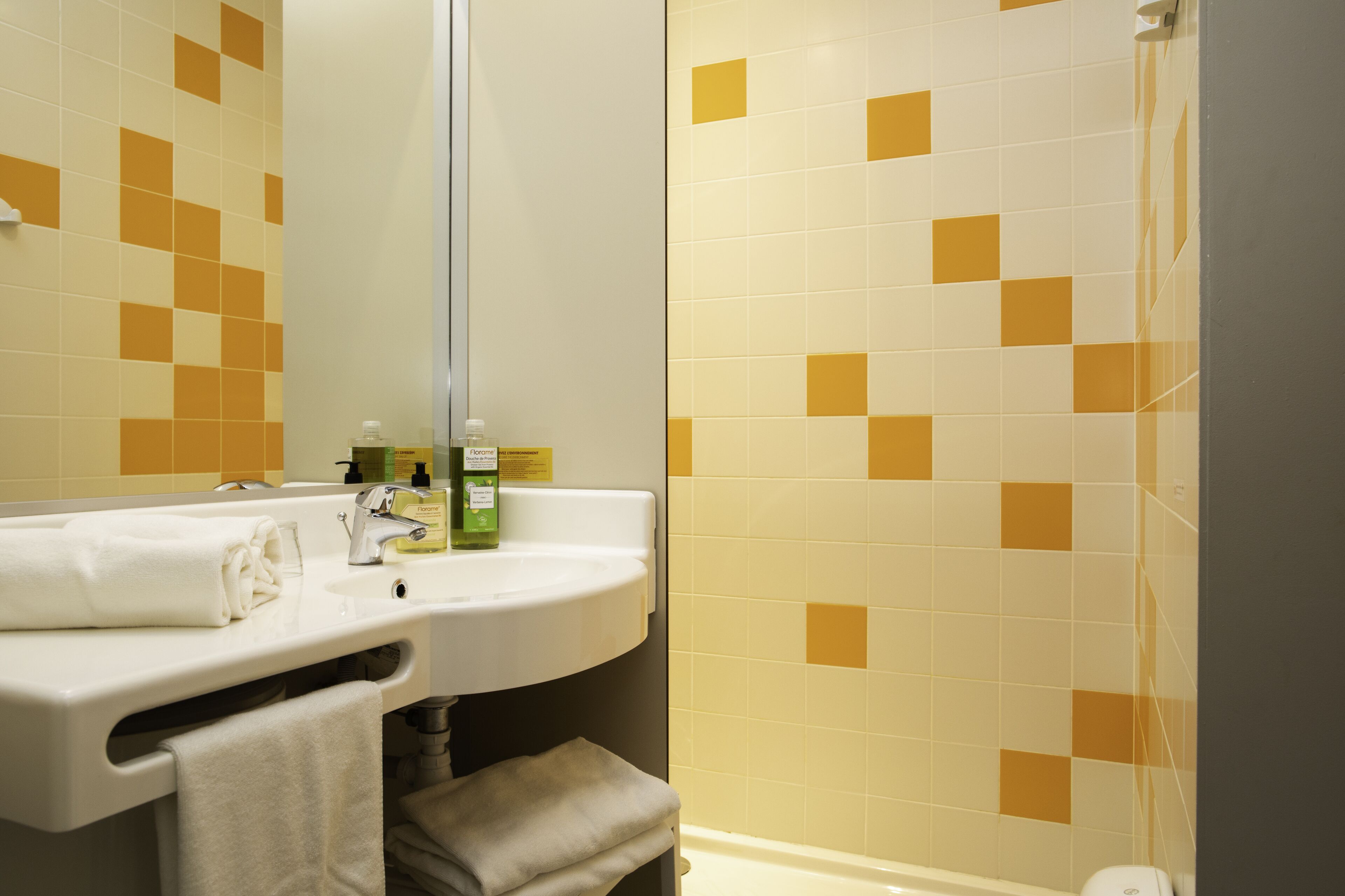 Ein Badezimmer mit Waschbecken, Spiegel und Dusche.