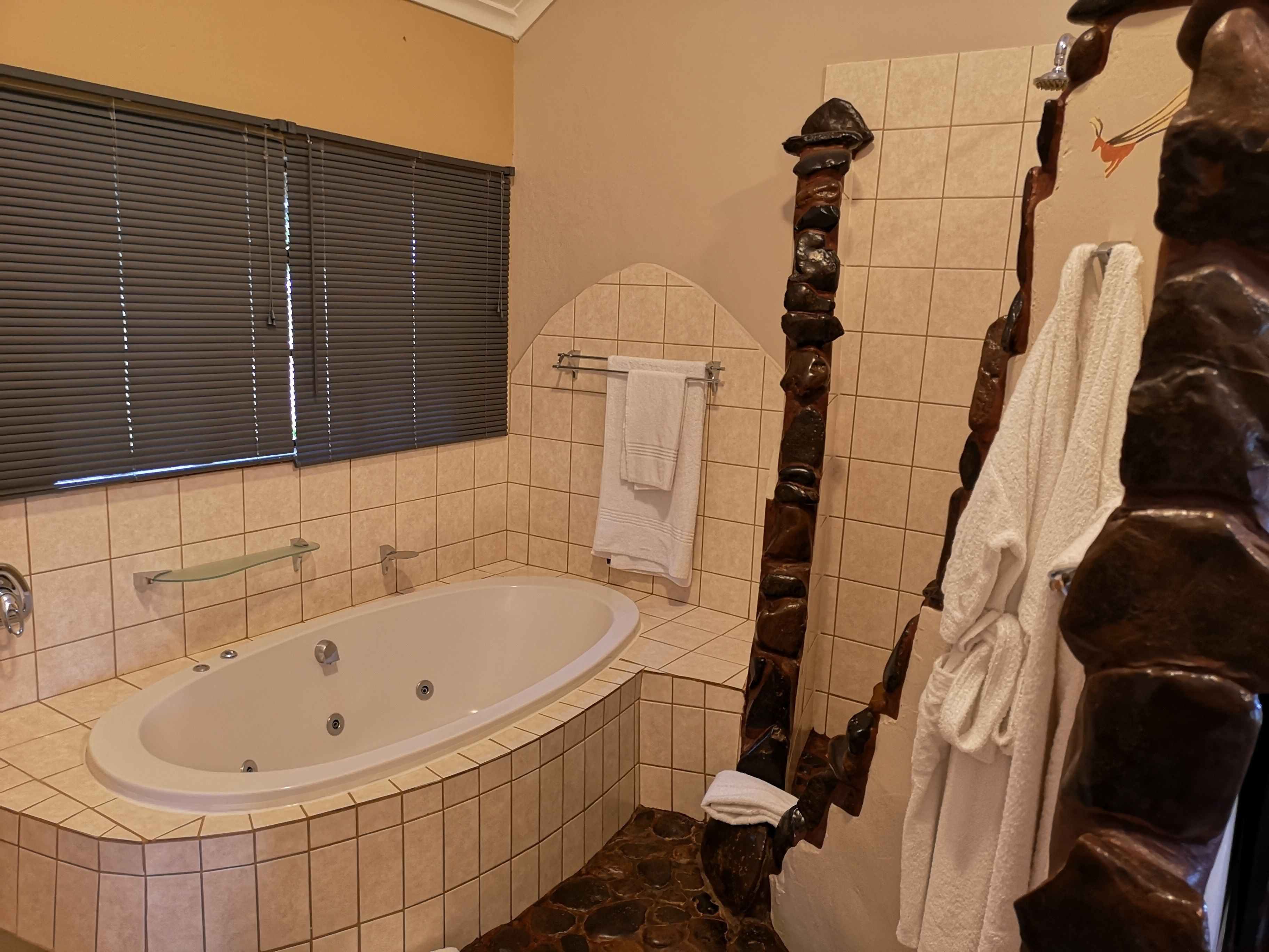 Un baño con bañera, ducha de madera y paredes con azulejos.