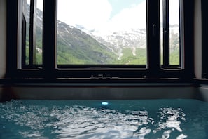 A window with a view of a mountainous landscape and a pool in the foreground. - The Dom Hotel Saas-Fee by Dorint (Saas-Fee)