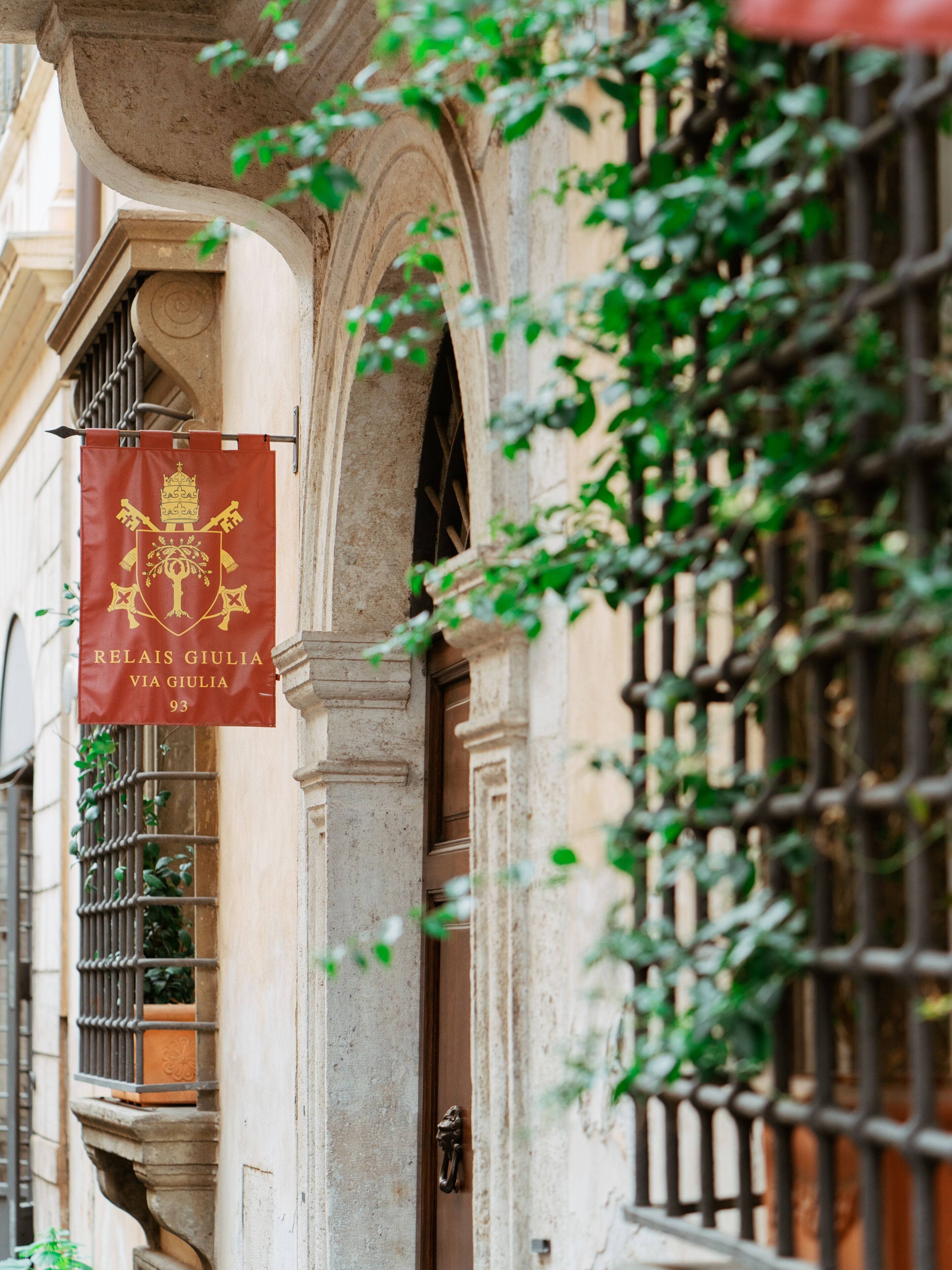 A building facade with a banner displaying "RELAIS GIULIA VIA GIULIA 93".