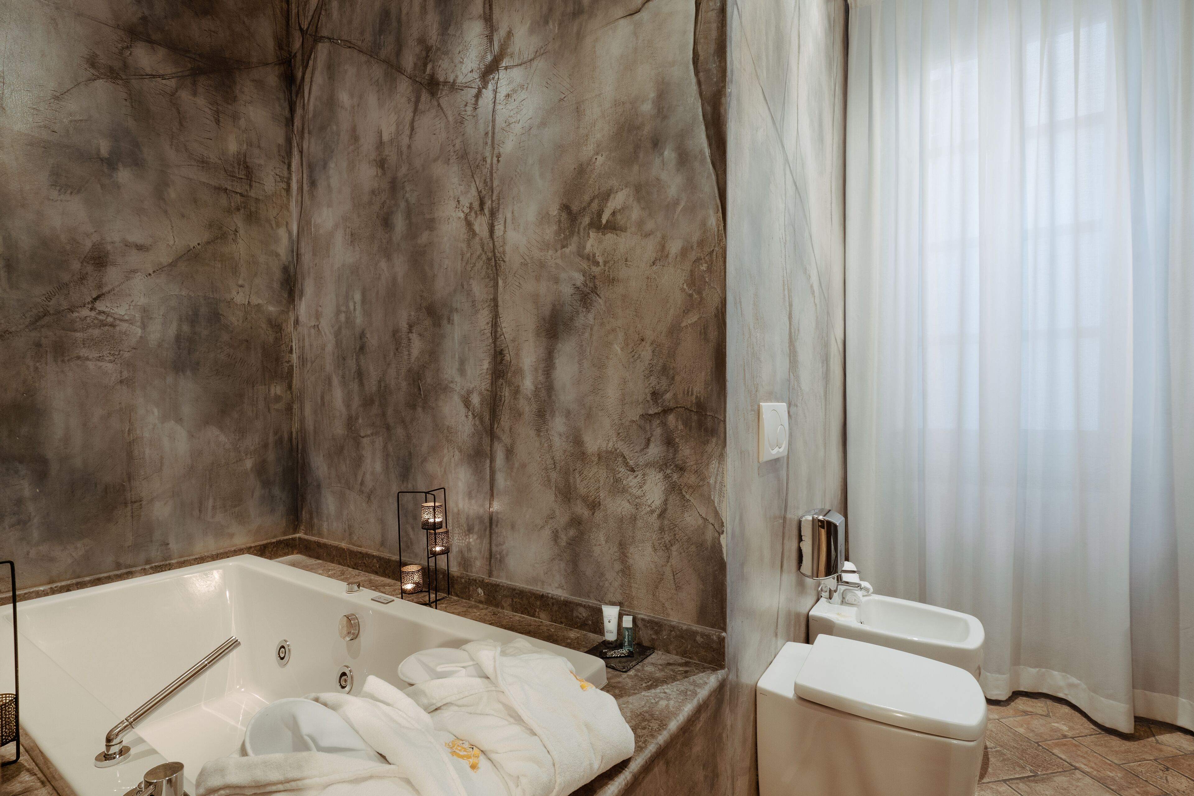 A modern bathroom with a large bathtub, a separate shower area, and a toilet.
