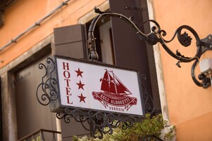 Segnaletica di un hotel con logo a forma di barca a vela e la scritta "AGLI ALBORETTI VENEZIA".