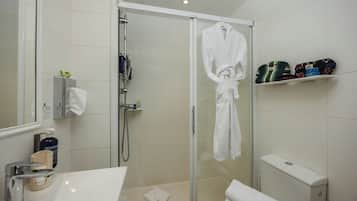 Une salle de bain moderne avec une douche à l’italienne en verre, une baignoire blanche et un meuble-lavabo avec un miroir.