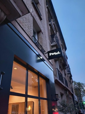 Un edificio con un letrero que dice 'Paris' sobre una ventana, indicando un establecimiento con temática parisina.