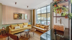 Una sala de estar moderna con un sofá, sillones, una mesa de centro y un amplio ventanal con vista a la calle.