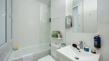 Une salle de bain avec une baignoire, des toilettes, un lavabo et un miroir.