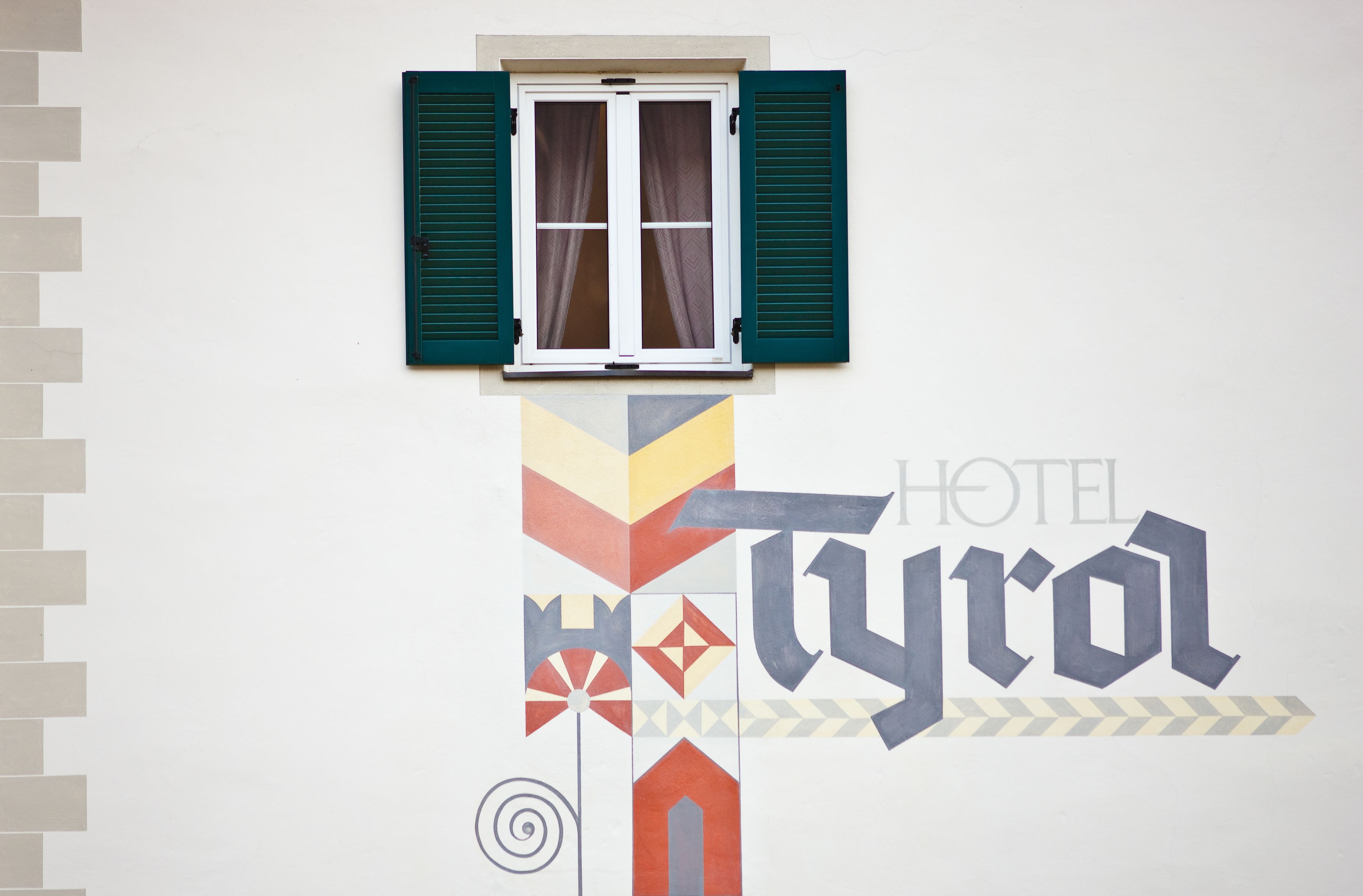 A wall with a window and a geometric design.