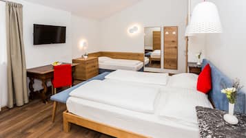 A modern hotel room with a wooden bed, a desk, a chair, a TV, and a mirror.