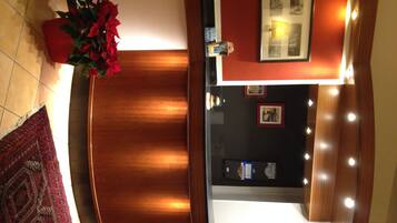 A reception area with a wooden reception desk, a potted plant, and framed pictures on the wall.