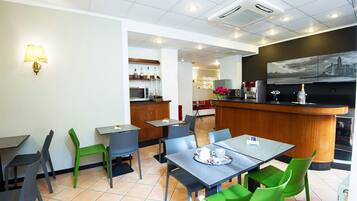 Un restaurante moderno con una zona de bar, mesas y sillas.