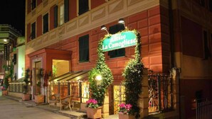 De gevel van een hotel met een groen bord waarop staat 