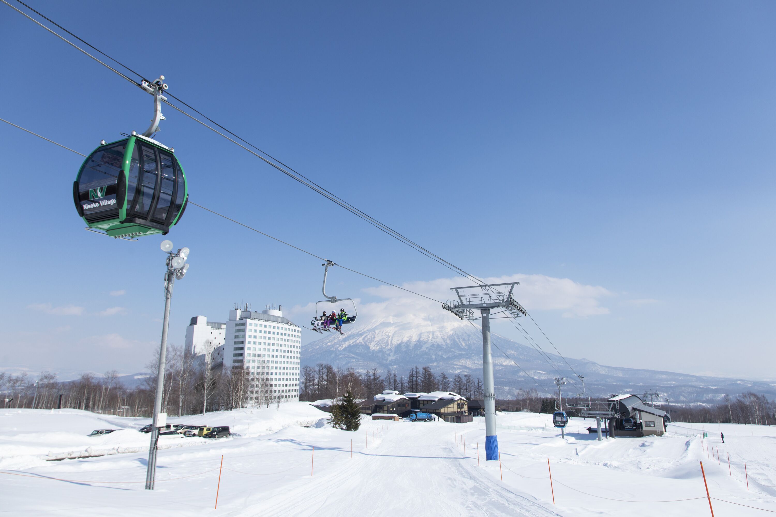 A cable car system at a ski resort with a mountain in the background.