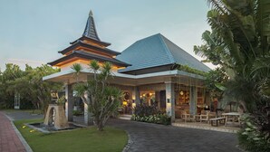 A traditional-style building with a pagoda-like structure, a covered outdoor seating area, and lush greenery. - The Wolas Villa & Spa (Seminyak)
