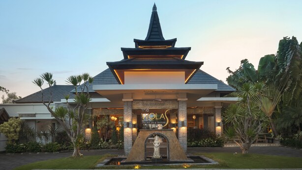 A traditional-style building with a pagoda-like roof, a statue in front, and a sign that reads "WOLAS." - The Wolas Villa & Spa (Seminyak)