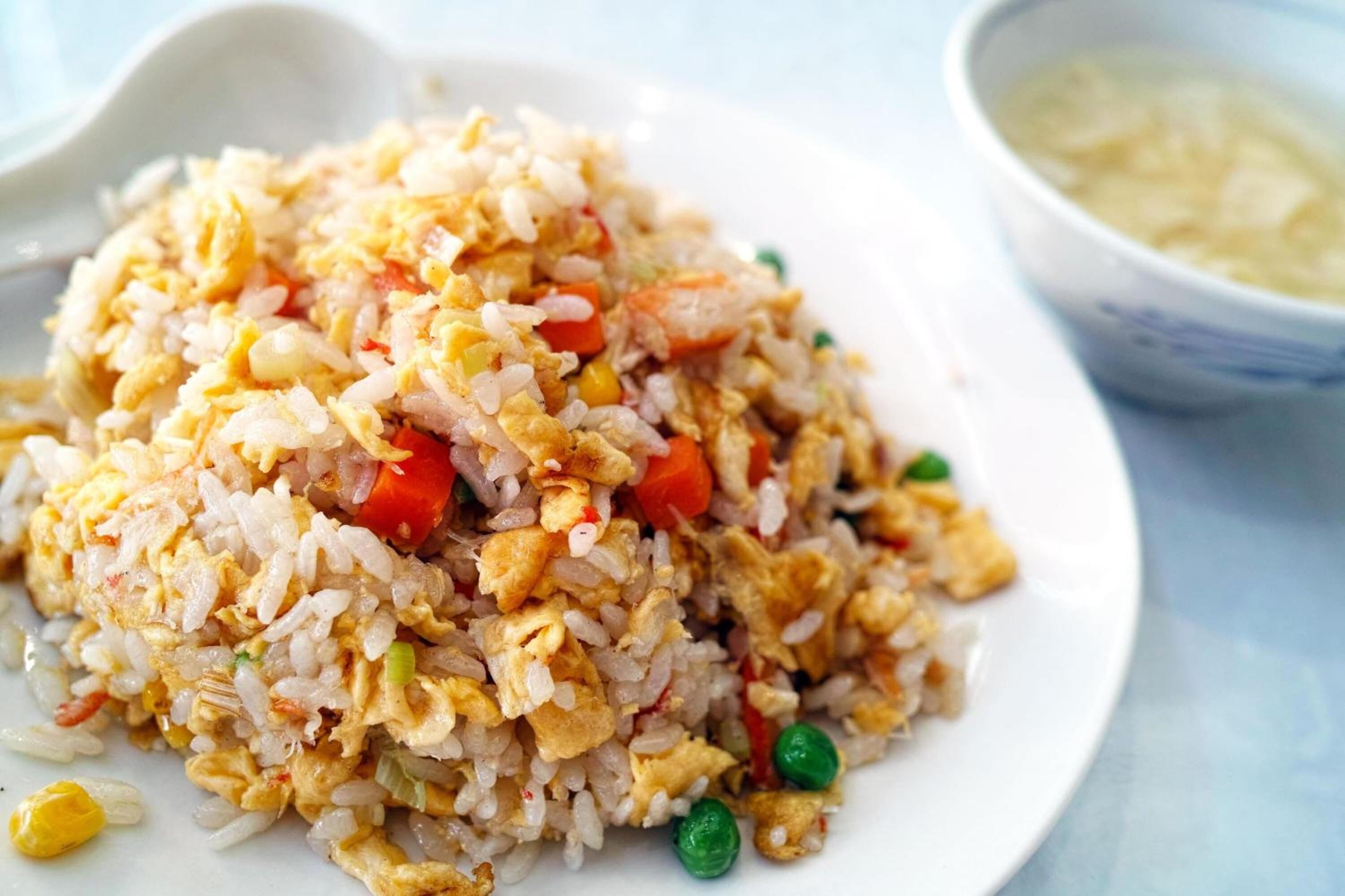 A plate of fried rice with vegetables and scrambled eggs.