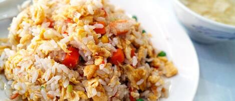 A plate of fried rice with vegetables and scrambled eggs.