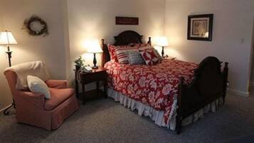 A bedroom with a bed, two bedside tables, a chair, and a lamp.