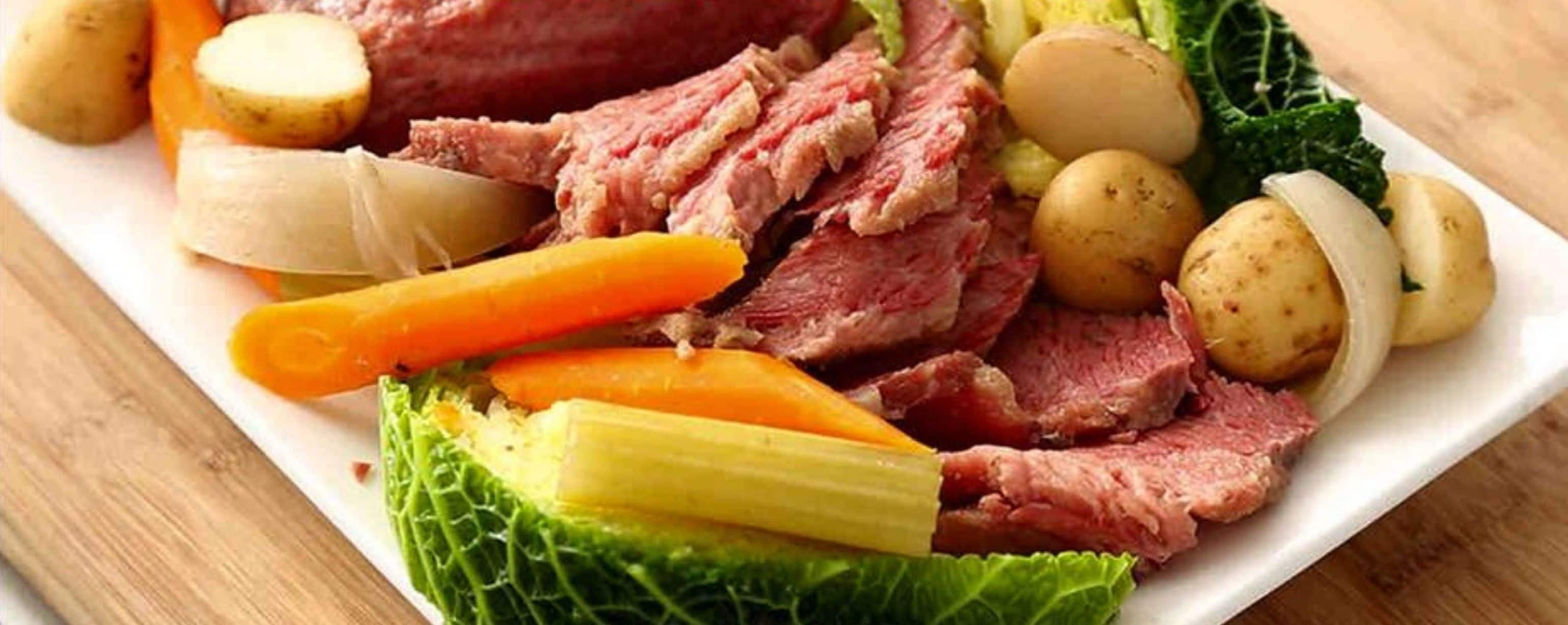 A plate of corned beef, potatoes, carrots, and celery.