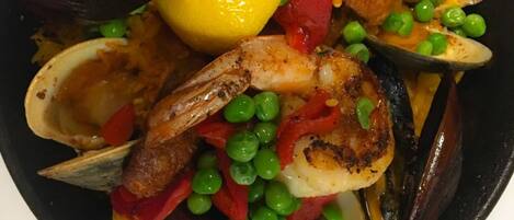 Un plato de mariscos con mejillones, camarones y guisantes.