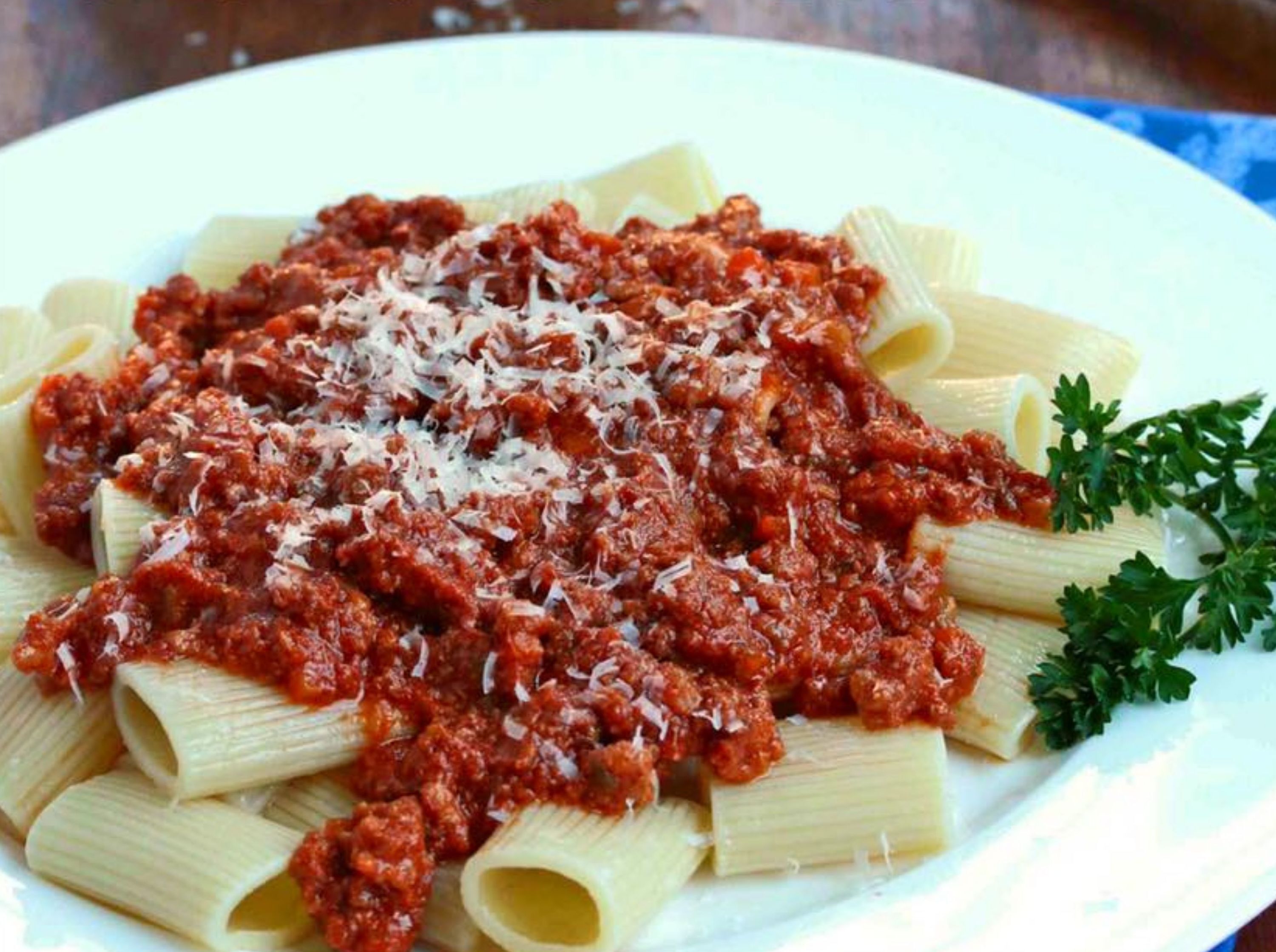 Un plato de pasta con salsa de tomate y queso rallado.
