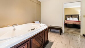 Un baño moderno con una bañera grande, un tocador con espejo y un banco.