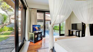 Amplia habitación con una cama grande, un televisor sobre un soporte de madera y vistas a una piscina y jardín.