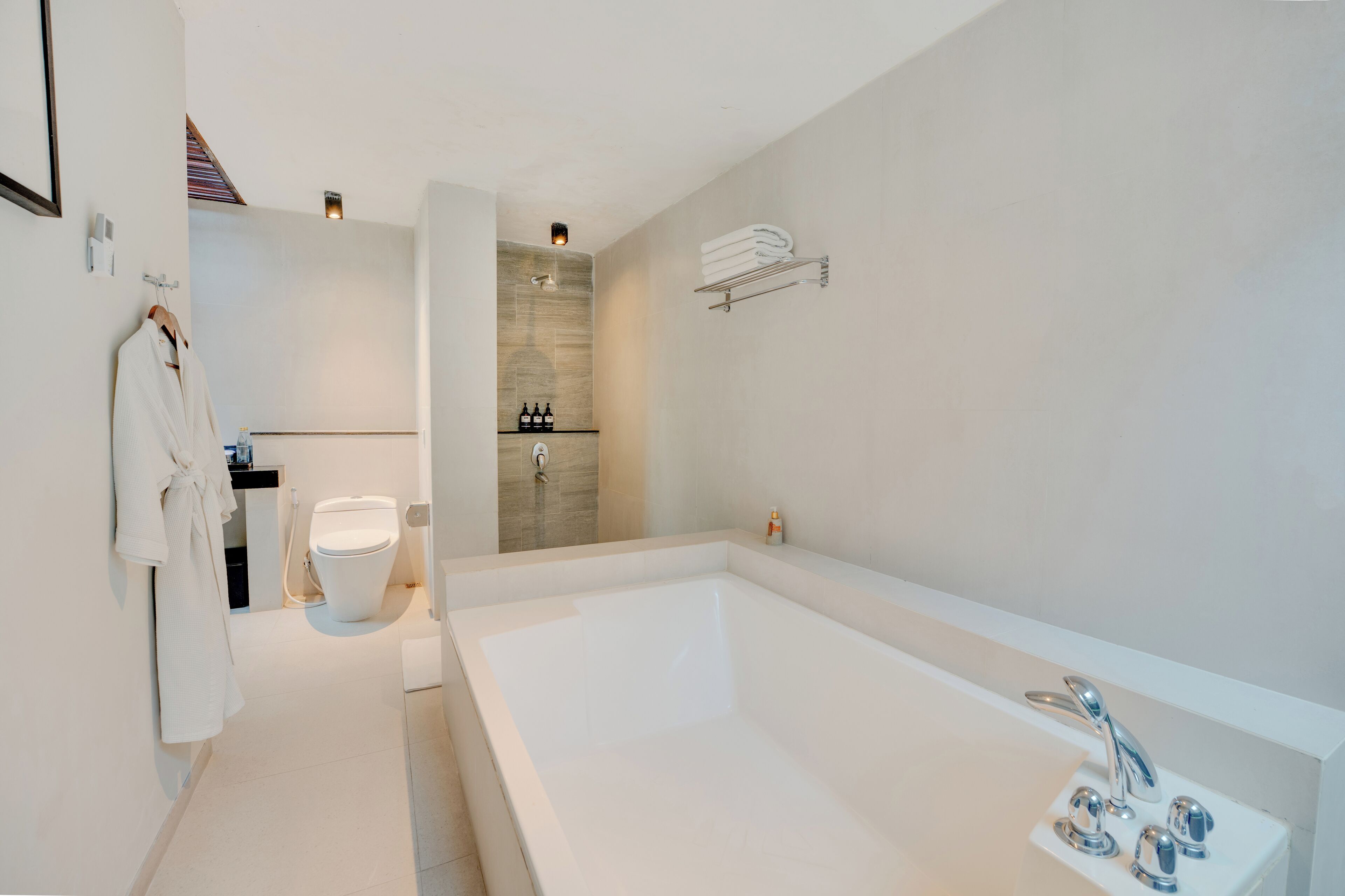 A modern bathroom with a large bathtub, a toilet, and a shower area.