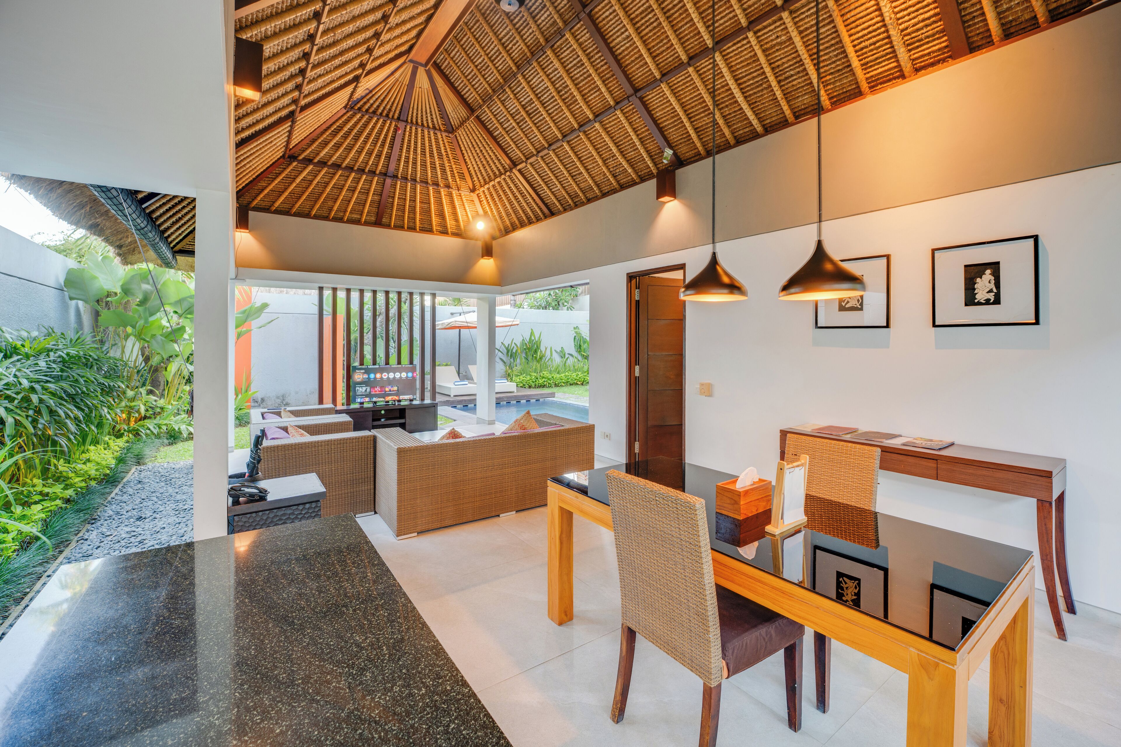 A modern interior with a dining area, a sofa, and a table with chairs.