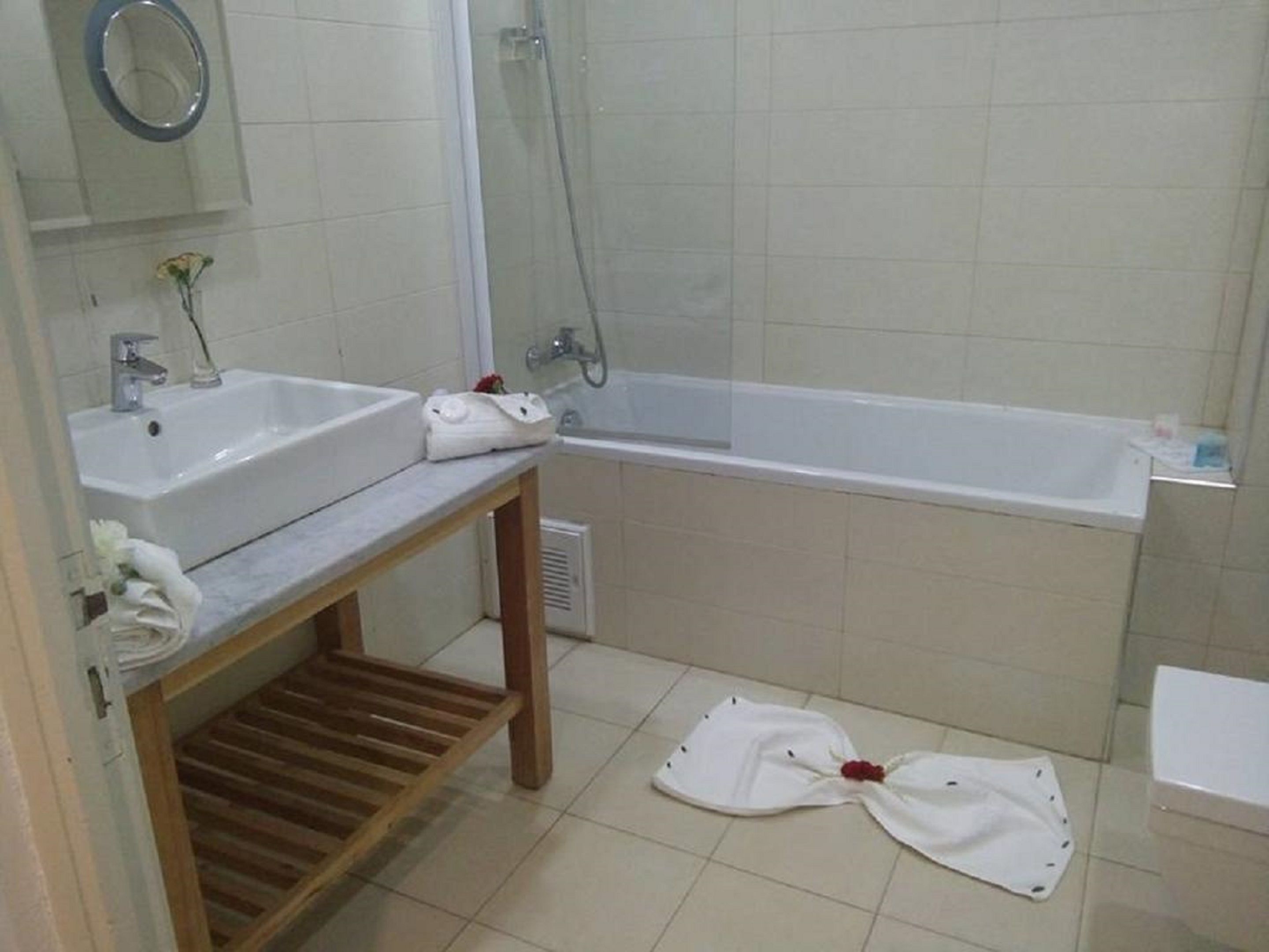 A bathroom with a sink, mirror, shower, and bathtub.