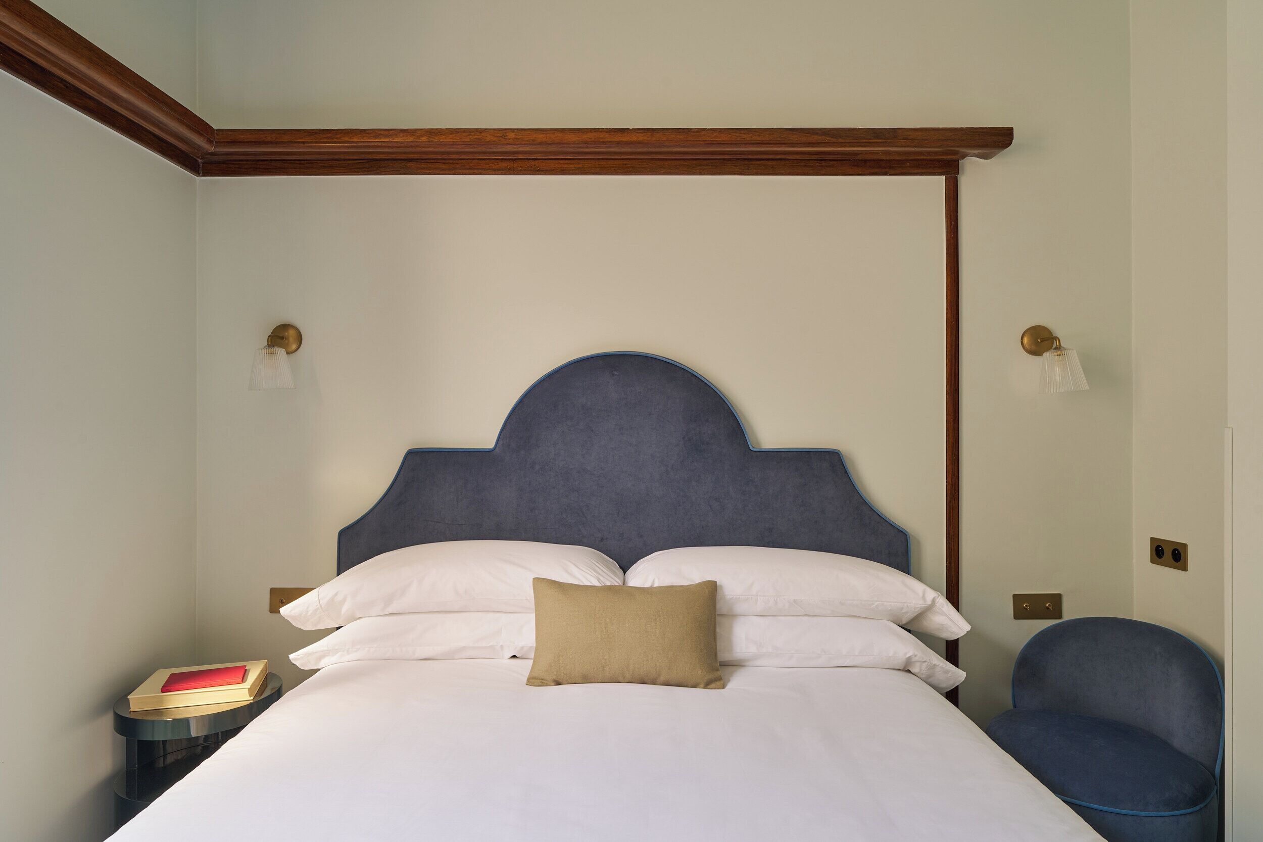 A bedroom with a bed, bedside tables, and a chair.
