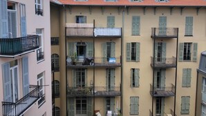 A multi-story building with balconies, a red-tiled roof, and a light yellow facade. - Chez Brigitte Guesthouse (Nice)