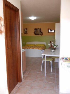Una habitación pequeña con una cama, una mesita y una silla.