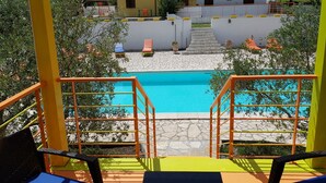 A pool area with a clear view of the pool, steps leading to a building, and a few lounge chairs. - Il Sogno di Alghero (Alghero)