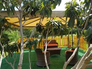 An outdoor seating area with wicker furniture and a yellow fence. - Il Sogno di Alghero (Alghero)
