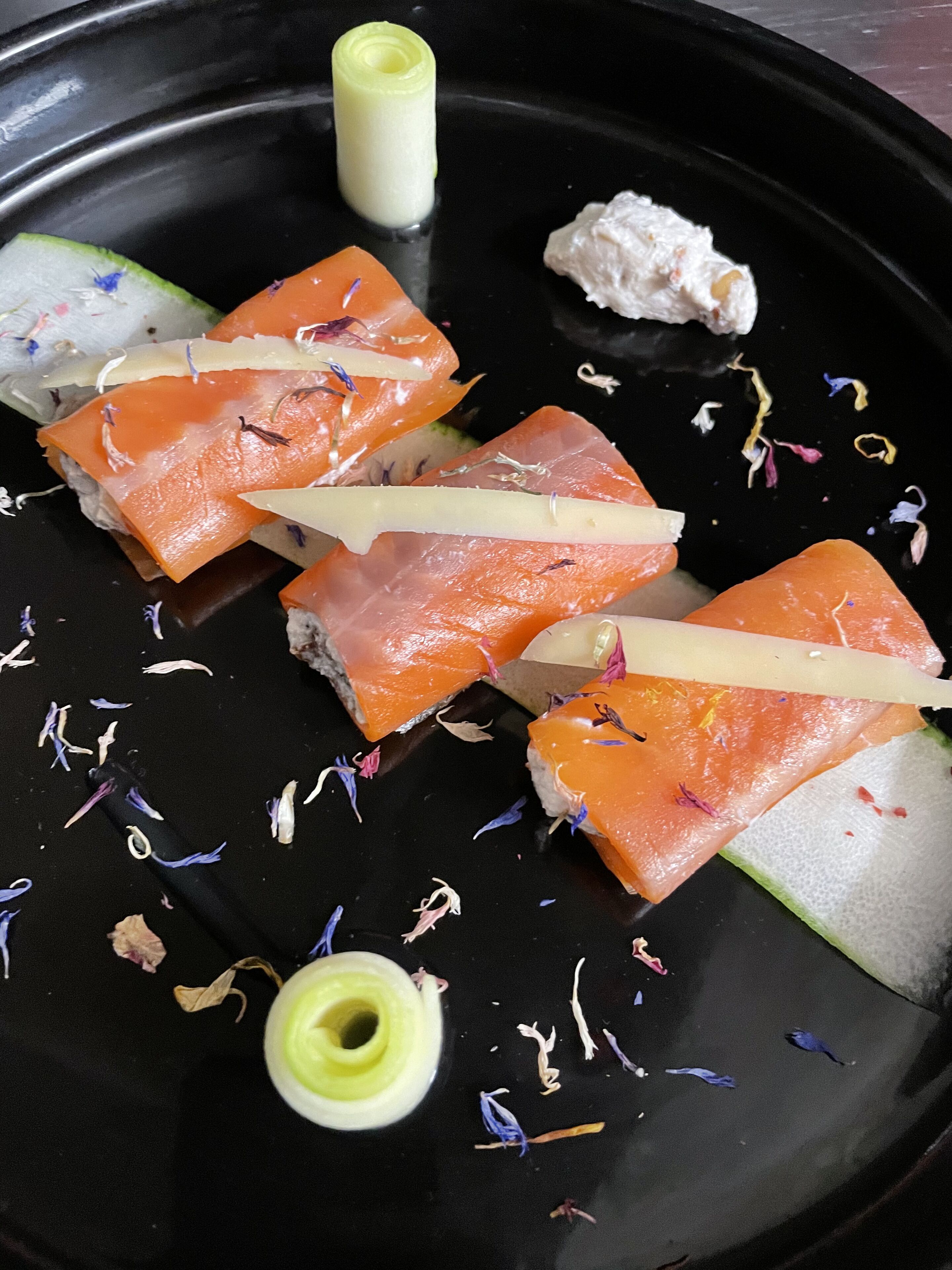 Piatto nero con sashimi di salmone, zenzero marinato e wasabi.