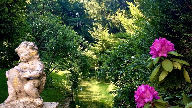 A garden with a statue, a pond, and blooming flowers. - Hôtel de la Vallée Heureuse (Poligny)
