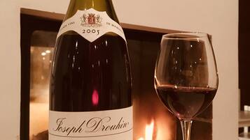 A bottle of Joseph Drouhin Nuits-Saint-Georges wine from 2005 next to a glass of red wine.