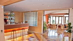 A hotel lobby with a bar area, seating, and a patterned floor. - Ares Hotel (San Giovanni la Punta)