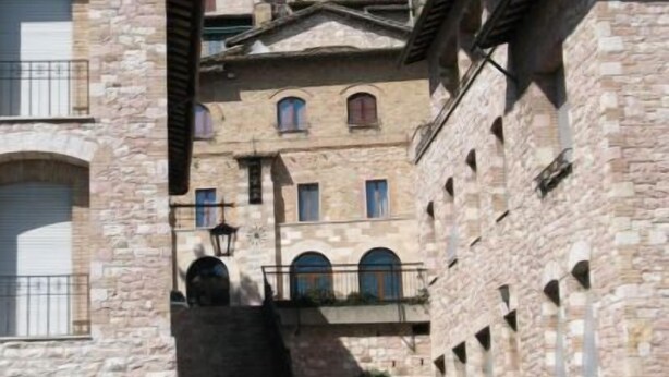 Un edifici de pedra amb diversos balcons i una escala que condueix a un nivell superior.