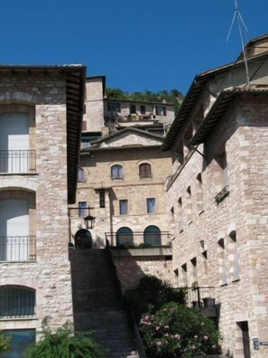 Un edificio de piedra con varios balcones y una escalera que lleva a un nivel superior.