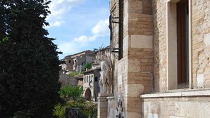 Edifici de pedra històric amb finestres apuntades i una estàtua.