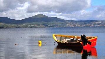 A boat on calm water with a mountain in the background.