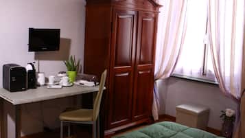A room with a desk, chair, wardrobe, bed, TV, and a window with curtains.