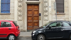 Un edificio con una puerta de madera grande y un letrero con el número 94.