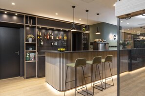 A modern bar area with a wooden counter, bar stools, and a variety of bottles and glasses. - Zeitwohnhaus Suite Hotel & Serviced Apartments (Erlangen)